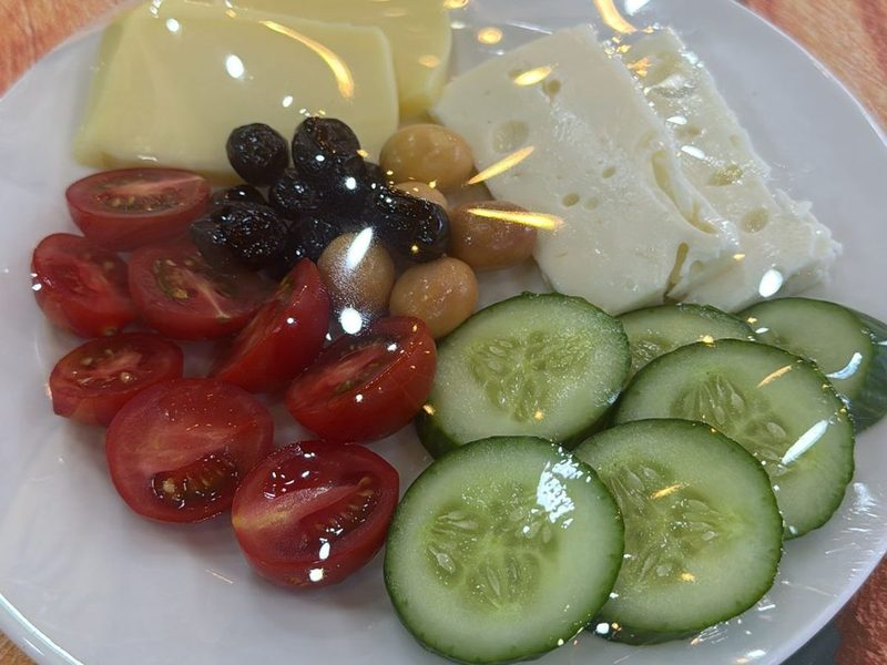Tabakta servis edilen kahvaltı: beyaz peynir, kaşar, zeytin, domates, salatalık